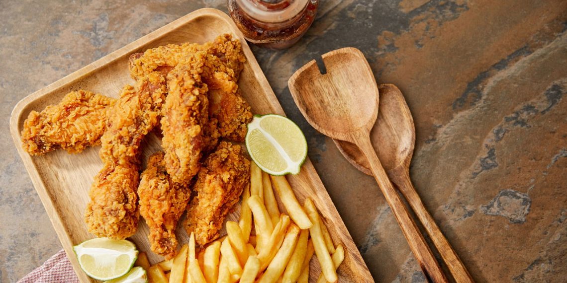 Tábua com frango frito e batatas fritas - Créditos: depositphotos.com / AntonMatyukha