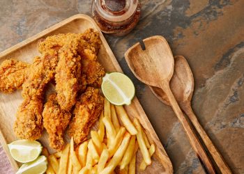 Tábua com frango frito e batatas fritas - Créditos: depositphotos.com / AntonMatyukha