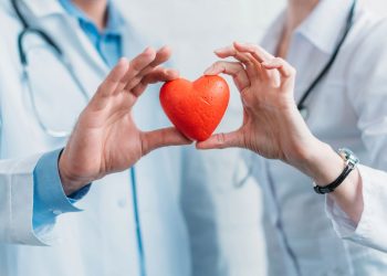 Médicos segurando um coração de plástico na mão - Créditos: depositphotos.com / VitalikRadko