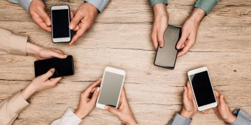 Pessoas utilizando celular - Créditos: depositphotos.com / KateNovikova