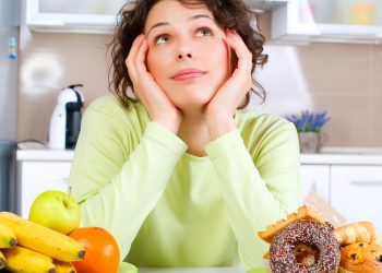 Mulher pensando entre comer vegetais e frutas ou comidas gordurosas - Créditos: depositphotos.com / Subbotina