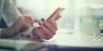 Mulher usando celular - Créditos: depositphotos.com / undrey