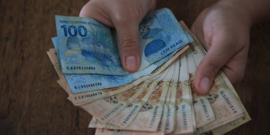 Dinheiro na mão-Créditos: depositphotos.com / joasouza