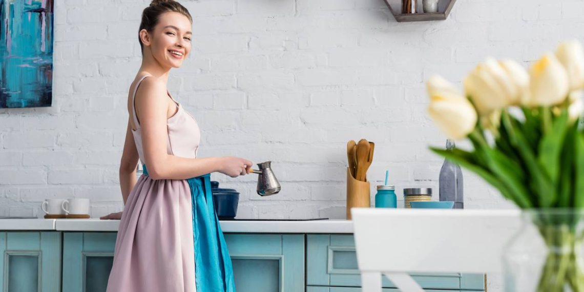 Mulher em cozinha com decoração em azul cobalto - Créditos: depositphotos.com / AndrewLozovyi
