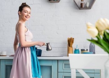 Mulher em cozinha com decoração em azul cobalto - Créditos: depositphotos.com / AndrewLozovyi