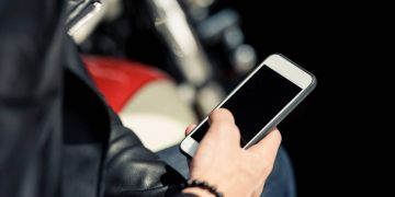 Homem segurando celular - Créditos: depositphotos.com / ArturVerkhovetskiy