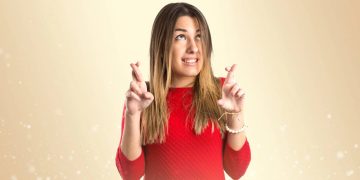 Mulher de dedos cruzados - Créditos: depositphotos.com / luismolinero