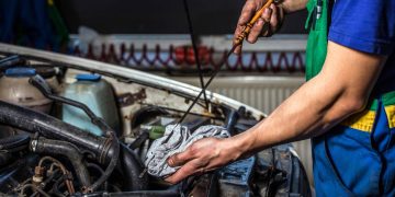 Mecânico checando nível de óleo - Créditos: depositphotos.com / jurra89