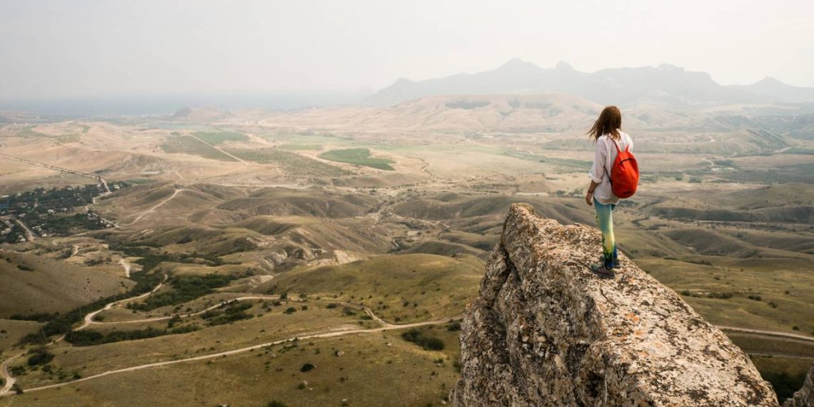 Jovem no alto da montanha - Créditos: depositphotos.com / YuliyaKirayonakBO