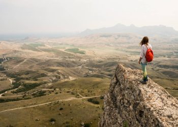Jovem no alto da montanha - Créditos: depositphotos.com / YuliyaKirayonakBO