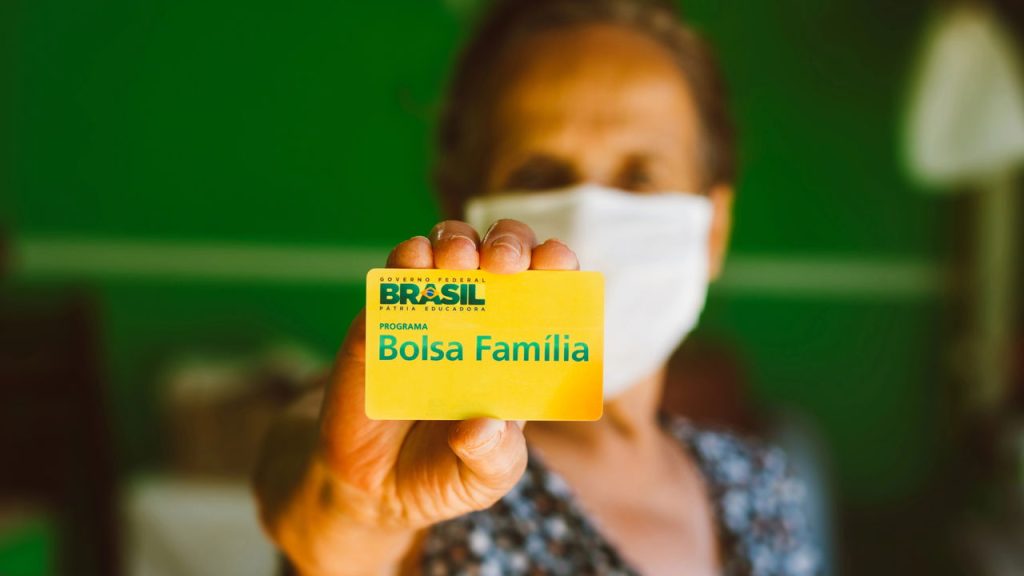 Beneficiário do Bolsa Família segurando cartão do benefício – Créditos: depositphotos.com / rafapress
