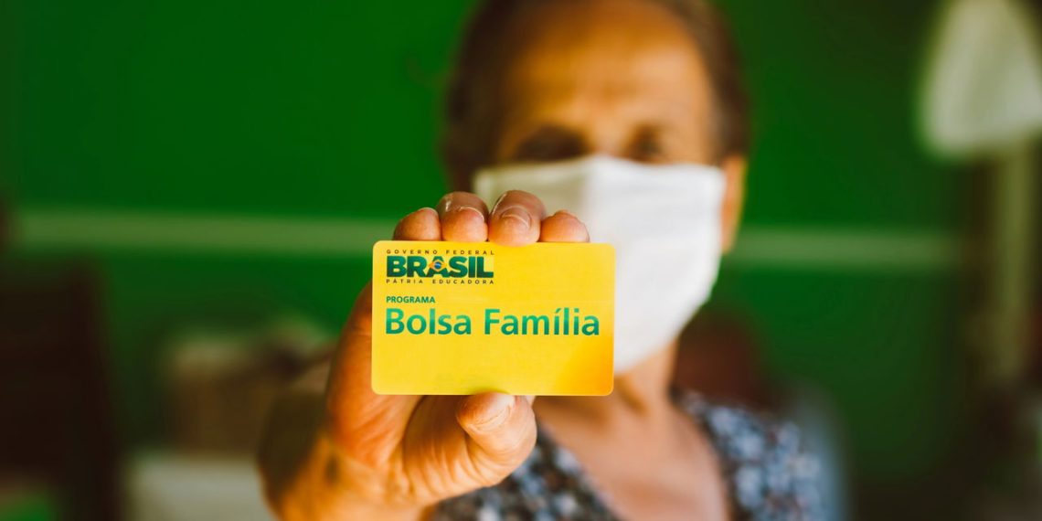 Beneficiário do Bolsa Família segurando cartão do benefício – Créditos: depositphotos.com / rafapress