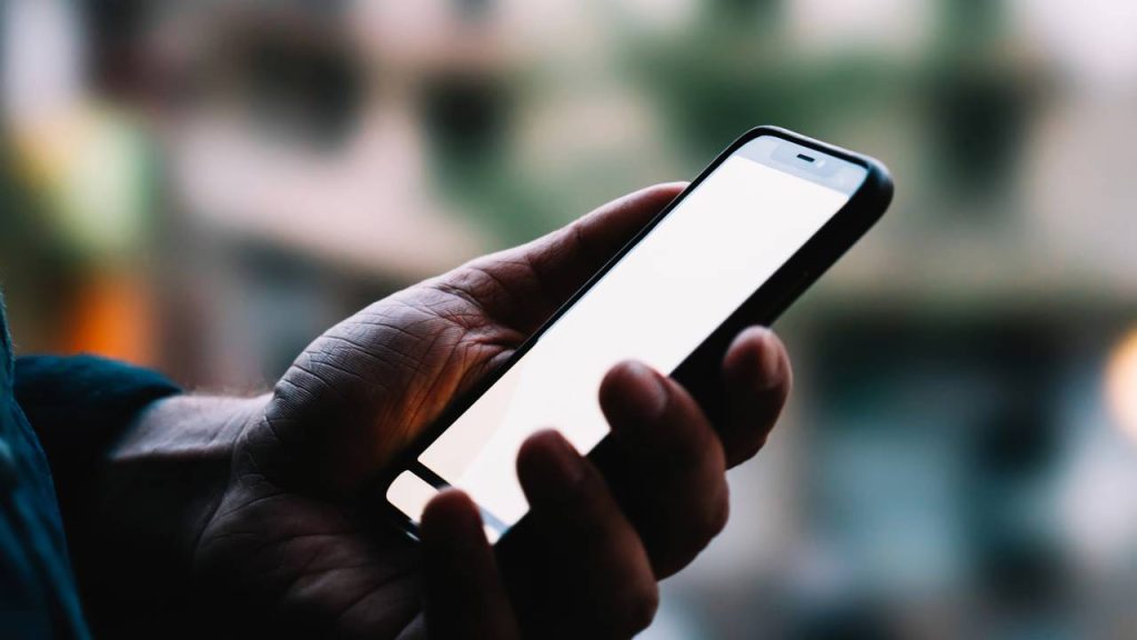 Homem usando celular - Créditos: depositphotos.com / GaudiLab