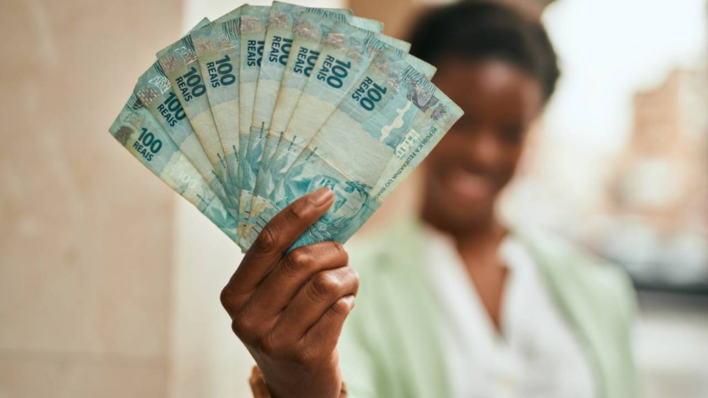 Mulher com montante de dinheiro na mão - Créditos: depositphotos.com / Krakenimages.com