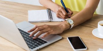 Pessoa com laptop e caderno de anotações - Créditos: depositphotos.com / HayDmitriy