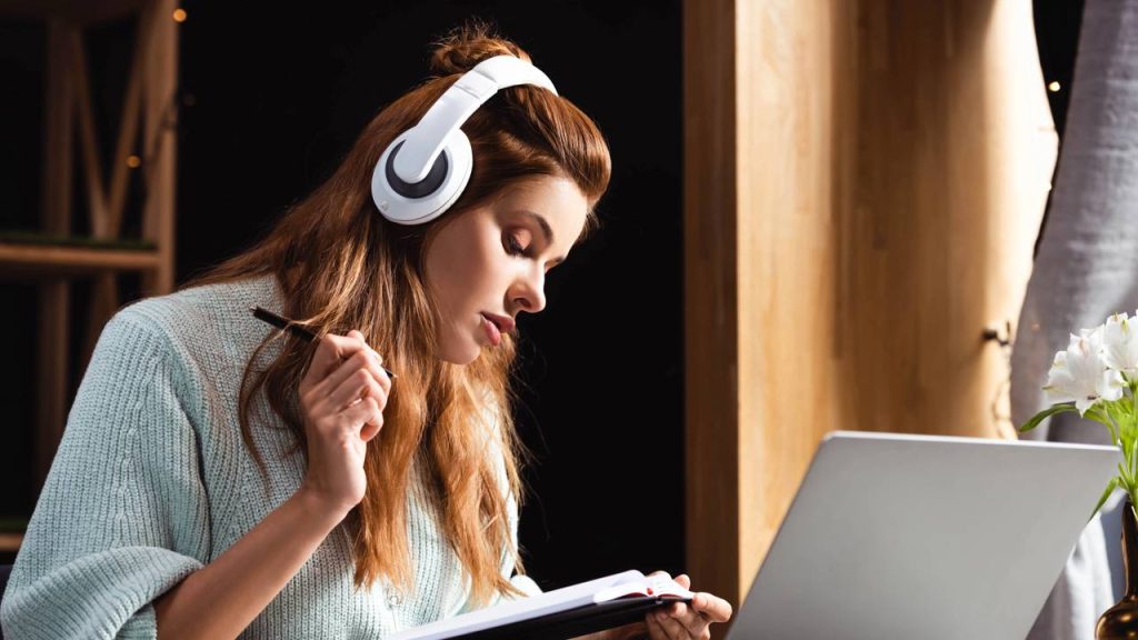 Jovem estudando no laptop com fones de ouvido - Créditos: depositphotos.com / HayDmitriy