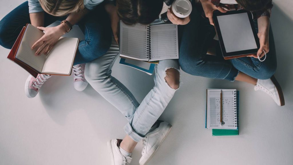Estudantes com livros abertos - Créditos: depositphotos.com / ArturVerkhovetskiy