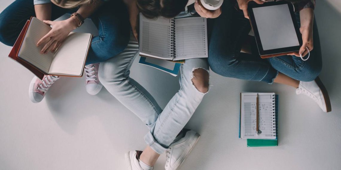 Estudantes com livros abertos - Créditos: depositphotos.com / ArturVerkhovetskiy