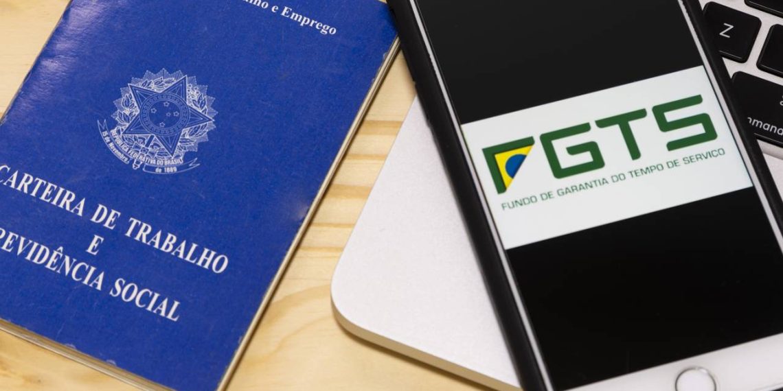 Carteira de trabalho Brasil e app FGTS em smartphone - Créditos: depositphotos.com / julioricco