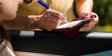 Guarda de trânsito aplicando multa - Créditos: depositphotos.com / Kzenon