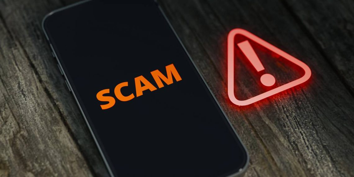 Celular com alerta de scam - Créditos: depositphotos.com / meshcube