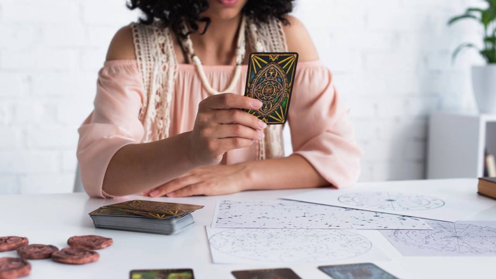 Astróloga com cartas de tarô - Créditos: depositphotos.com / IgorVetushko