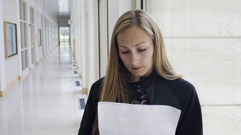 Mulher revisando conteúdo numa folha de papel - Créditos: depositphotos.com / yobro10