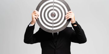 Homem segurando alvo - Créditos: depositphotos.com / IgorVetushko