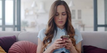 Mulher fazendo anotações no celular - Créditos: depositphotos.com / stockbusters