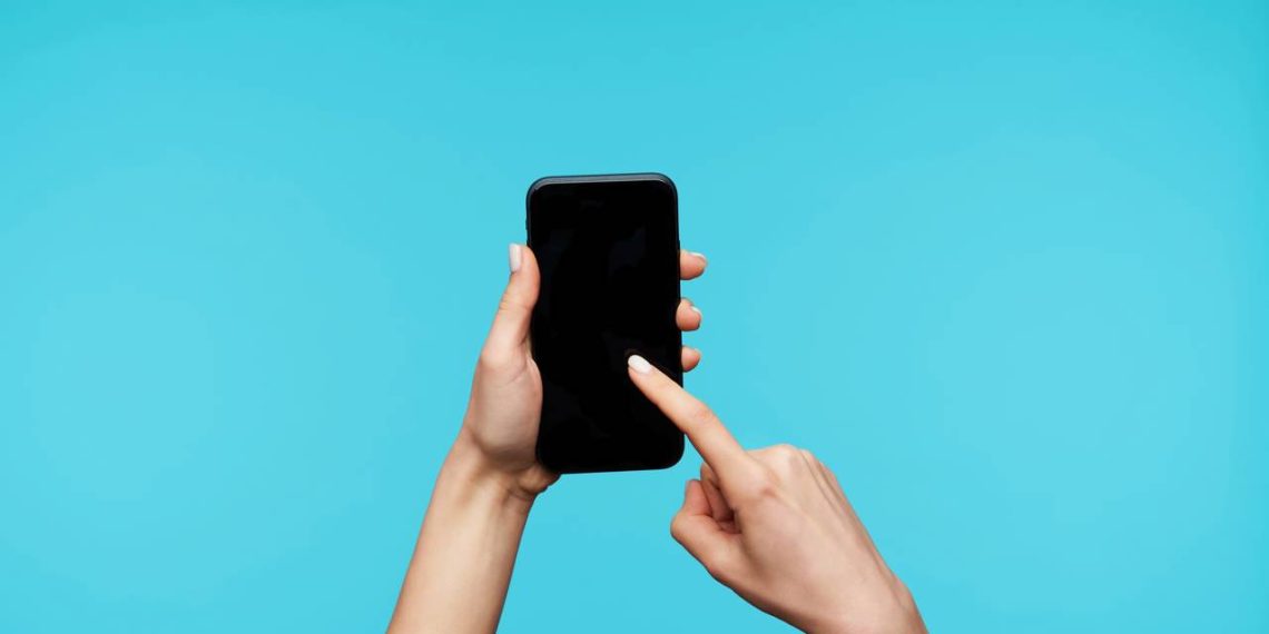 Pessoa segurando celular - Créditos: depositphotos.com / timtimphoto