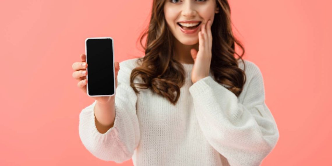 Mulher segurando celular - Créditos: depositphotos.com / AndrewLozovyi