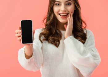 Mulher segurando celular - Créditos: depositphotos.com / AndrewLozovyi