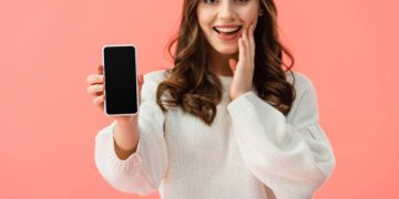 Mulher segurando celular - Créditos: depositphotos.com / AndrewLozovyi