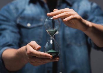 Homem segurando ampulheta - Créditos: depositphotos.com / HayDmitriy