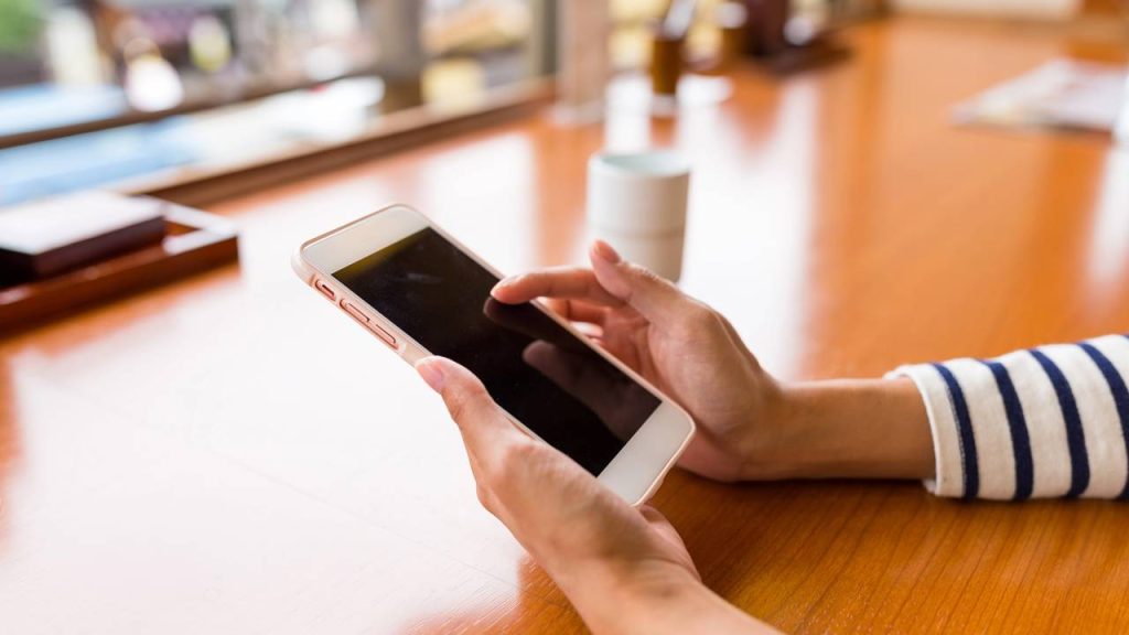 Mulher usando celular - Créditos: depositphotos.com / leungchopan