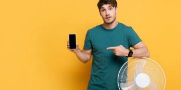 Homem segurando smartphone - Créditos: depositphotos.com / IgorVetushko