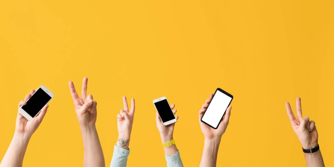 Pessoas com celulares na mão - Créditos: depositphotos.com / serezniy