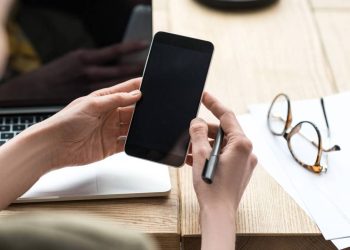 Mulher usando celular - Créditos: depositphotos.com / Y-Boychenko