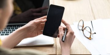 Mulher usando celular - Créditos: depositphotos.com / Y-Boychenko