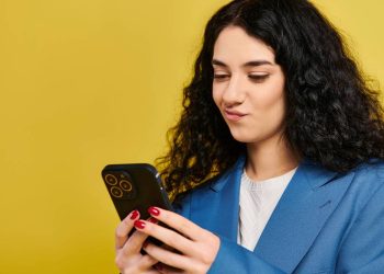 Jovem olhando o celular - Créditos: depositphotos.com / IgorVetushko