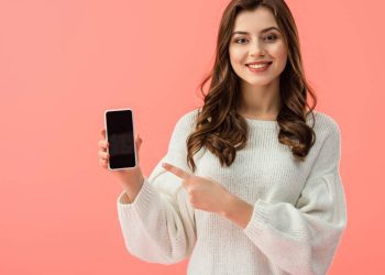 Mulher apontando para celular - Créditos: depositphotos.com / AndrewLozovyi